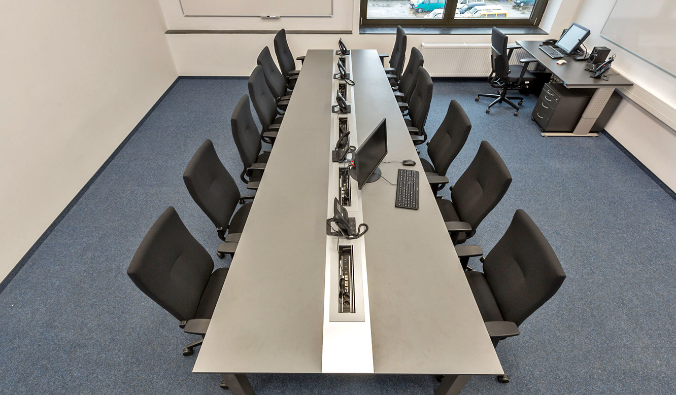 JST - Autorisierte Stelle Digitalfunk Niedersachsen: AllMedia conference table in trapezoid shape for optimized view of the large screen