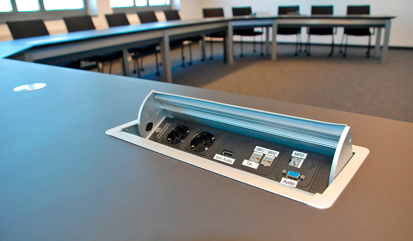 JST Referenzen - Siemens: Leitwartentische. Power-Port-Data-Box flächenbündig in den Konferenztisch integriert