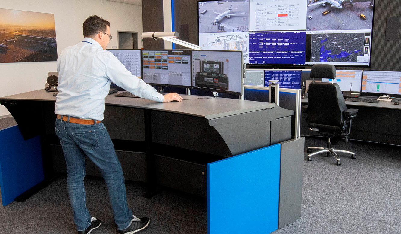 JST Reference Control Room EFM Munich Airport: Height-adjustable control desk.
         Standing position.