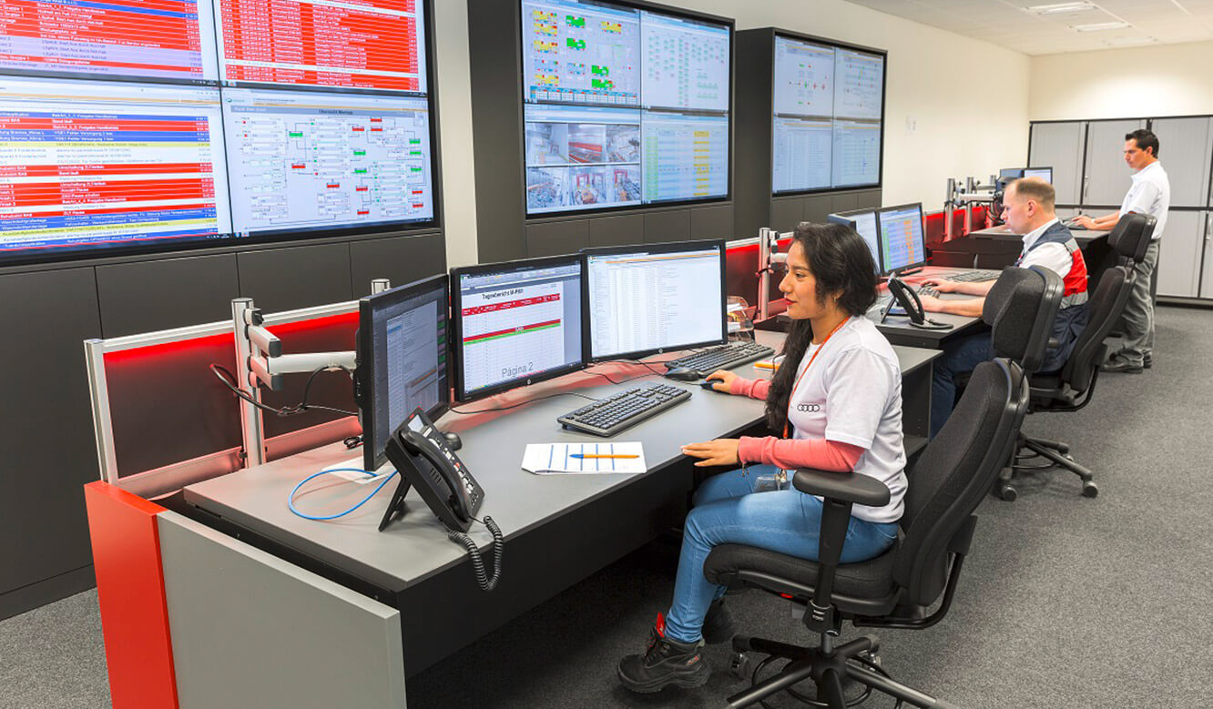 JST Audi Mexico: Operator in control room at control desk in front of display wall