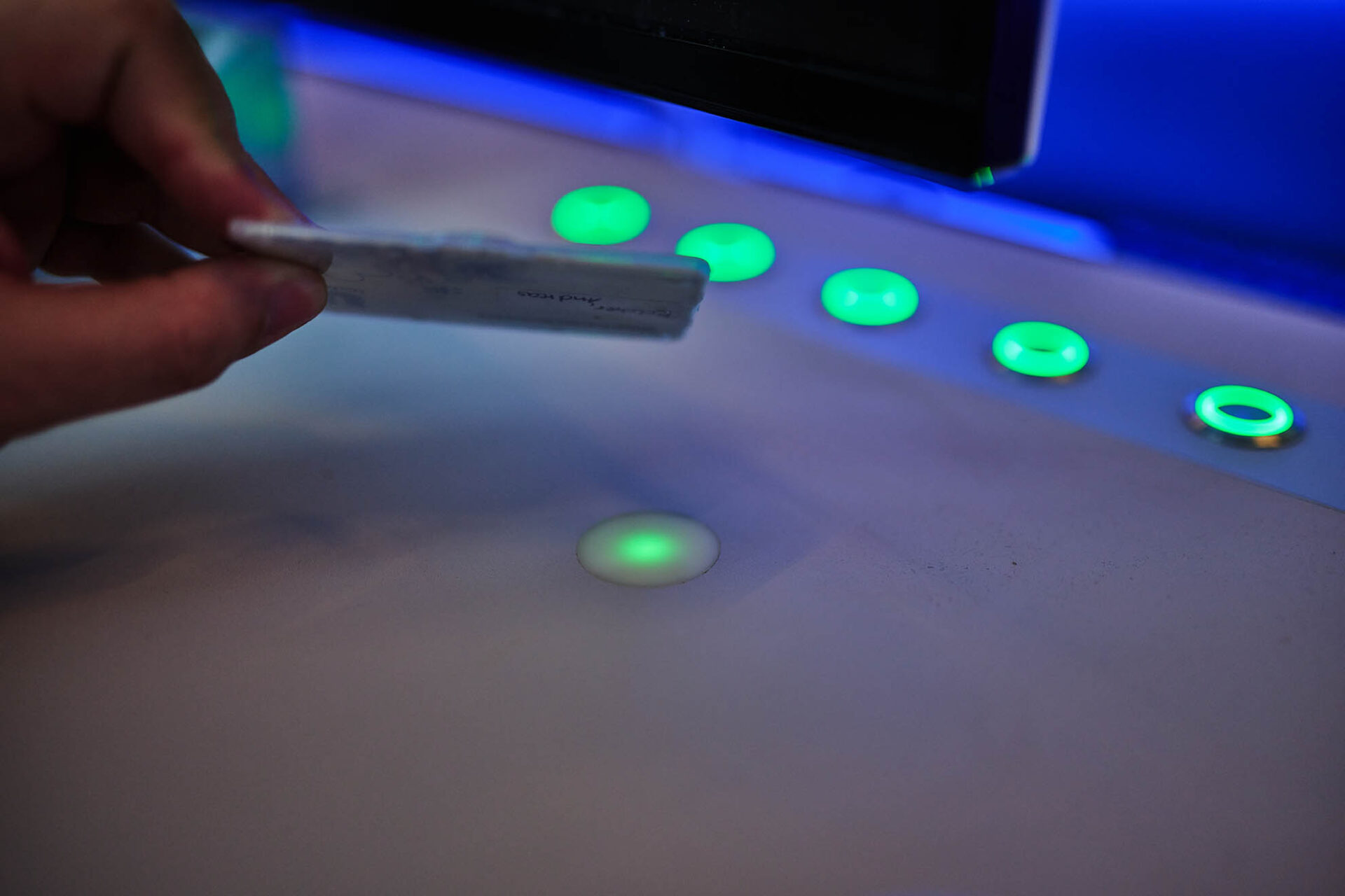 Mitarbeiterausweis wird zum Login an ein beleuchtetes UserCard-Lesefeld im Produktionsleitstand gehalten.